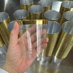 10 Oz clear plastic cups with elegant gold rims for serving wine, cocktails, and beverages at parties and events.